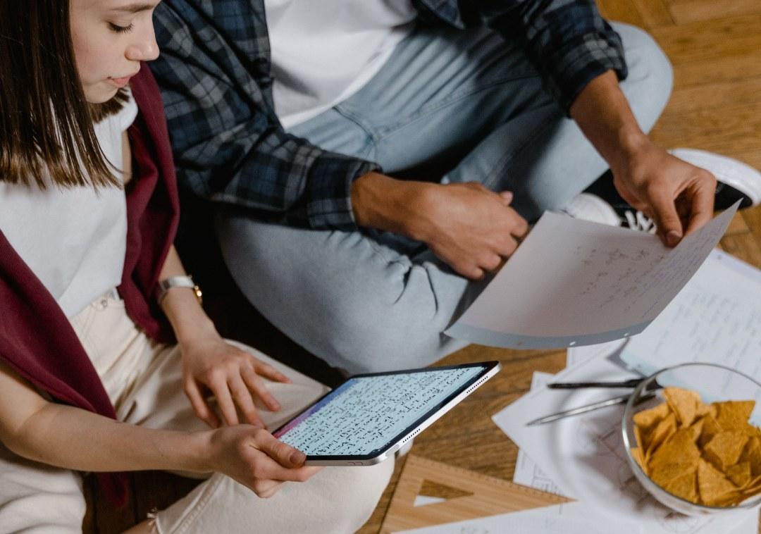 Two students studying with a tablet and handwritten notes